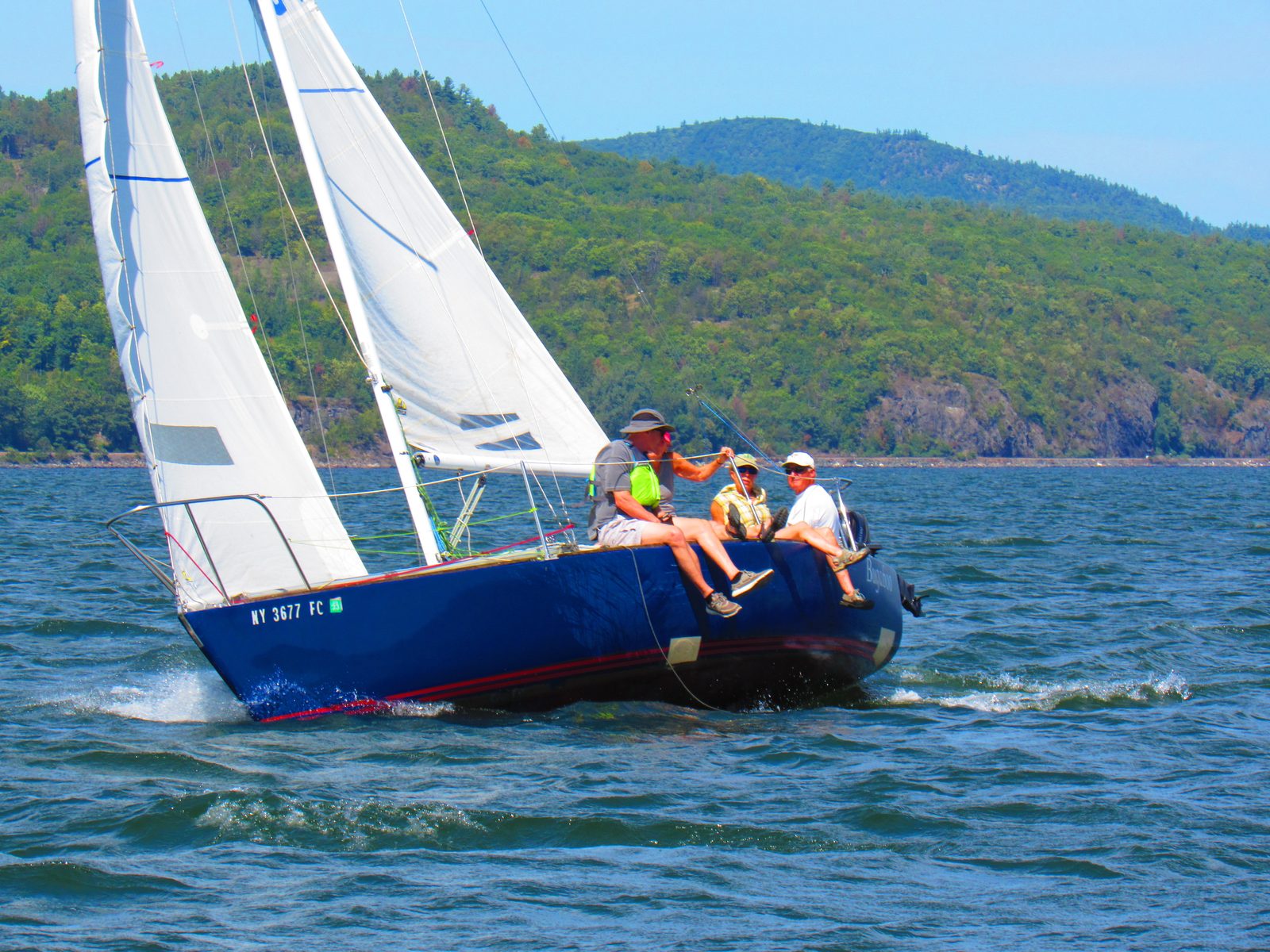 Blue-hulled sailboat racing on Lake Champlain